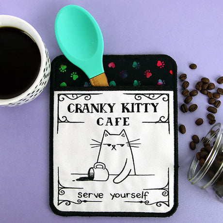 an in-the-hoop machine embroidered potholder with a cat that says, "cranky kitty cafe, serve yourself"