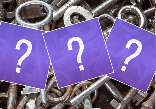 metal keys with purple cards layered on top featuring question marks