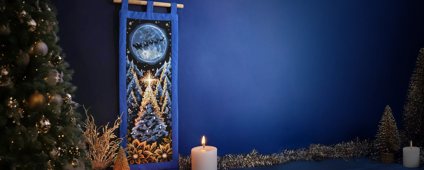 Decorative wall hanging with Christmas scene, candle, and tree against a blue background