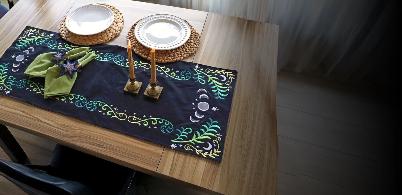 Decorative machine embroidered table runner with celestial leaf design and in-the-hoop stars on a wooden table.