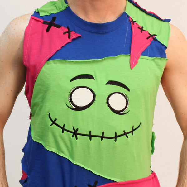 Embroidered patches form a cartoon face, stitched on fabric in bold colored panels; machine embroidery design is visible.