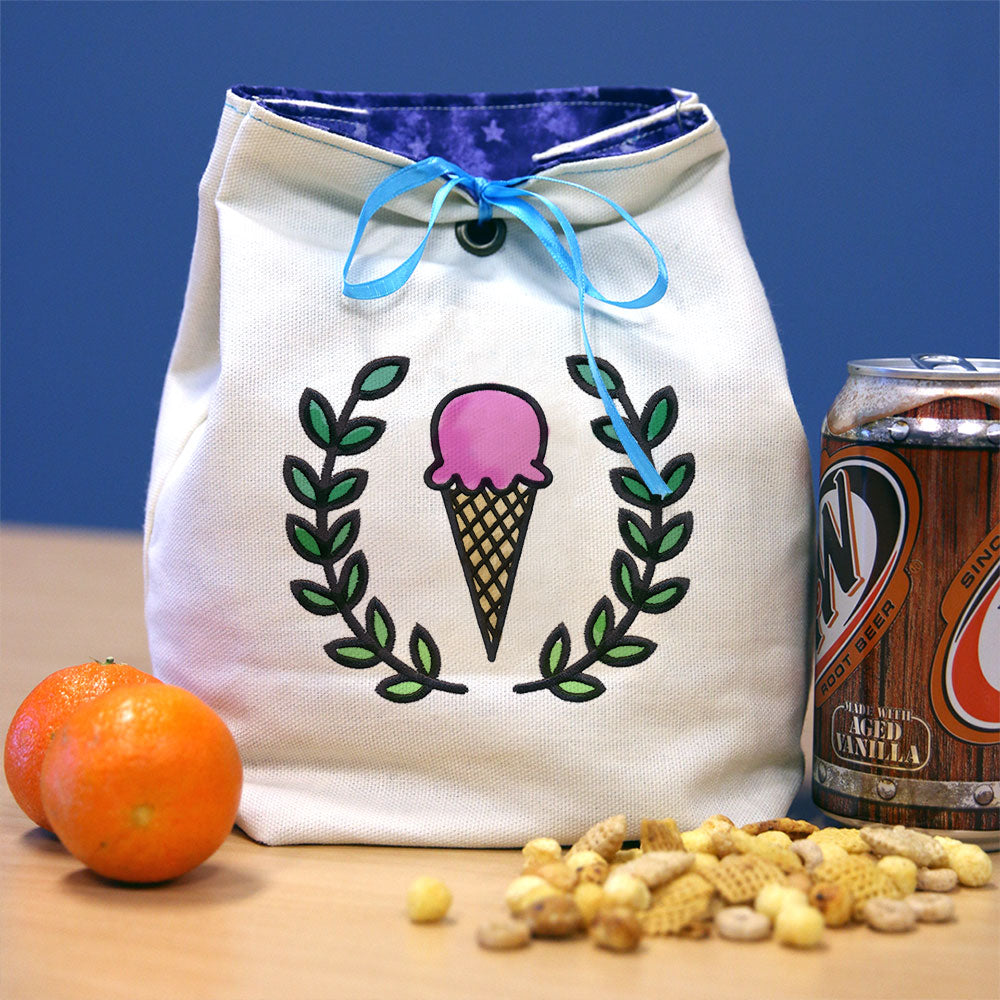 White bag with visible Daydream Doodles digitally downloadable machine embroidery design, shown alongside fruit and cereal.