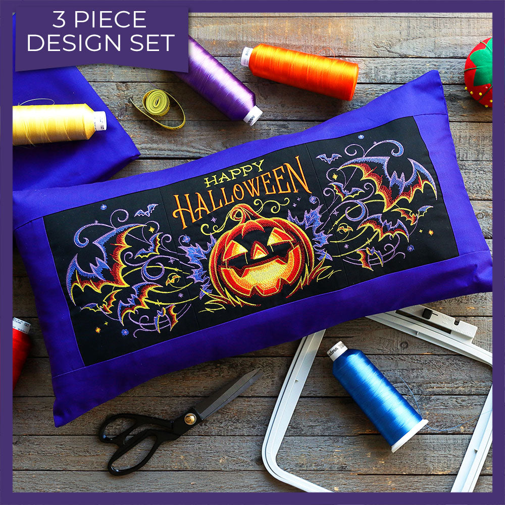 Rectangular pillow featuring embroidered jack o’ lanterns and bats from a digitally downloadable embroidery design.