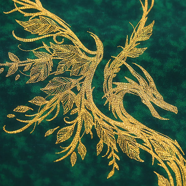 Gold leafy embroidery forms dragon-like branches on textured green fabric; available as a digital machine embroidery design.