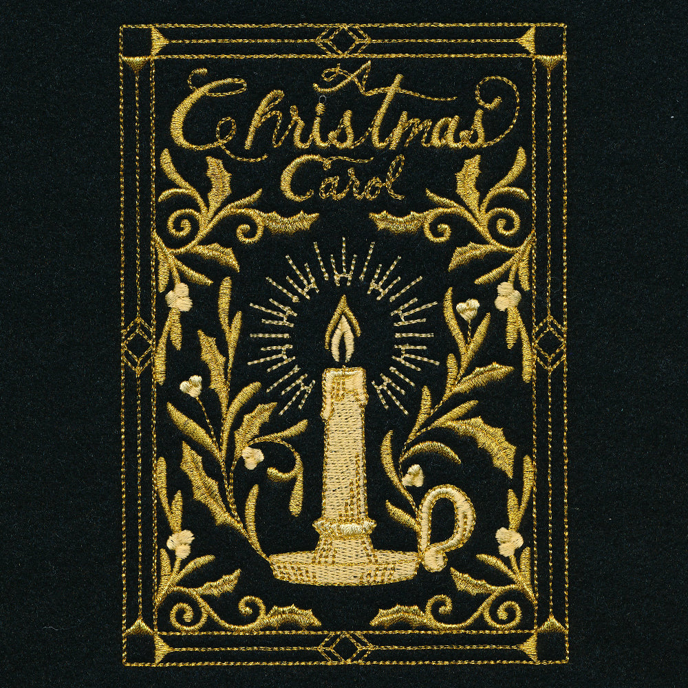 Gold embroidery on black fabric features a lit candle in a holder surrounded by decorative holly leaves and the words "A Christmas Carol" in ornate script.