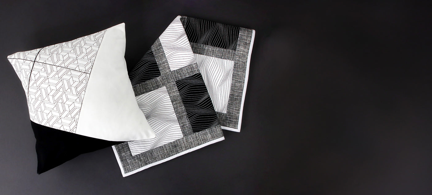 Black and white machine embroidery optical illusion designs on a quilt and pillow
