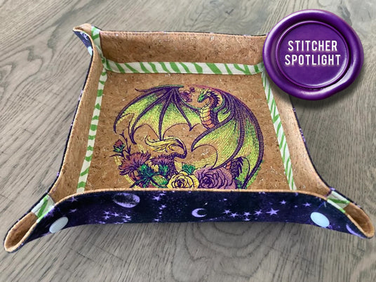 Cork and fabric catch all with a machine embroidered dragon & flowers motif. A tag that reads "Stitcher Spotlight"