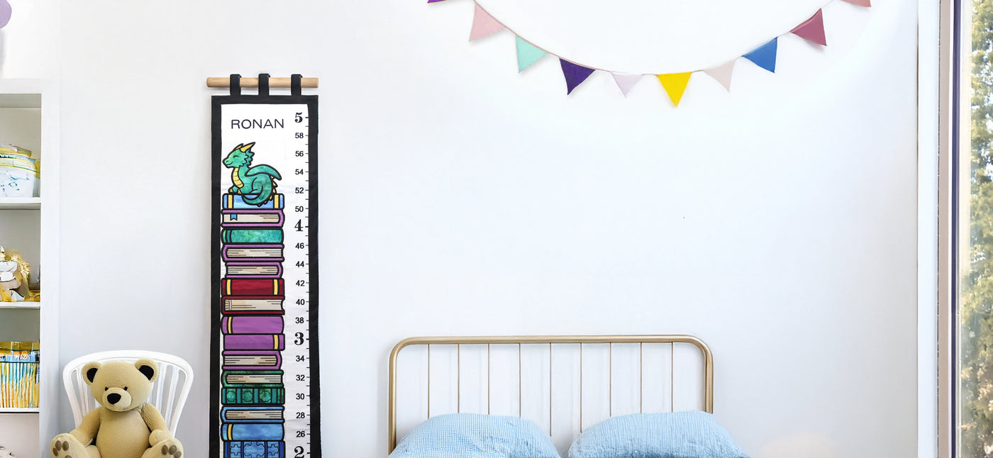 Personalized machine embroidery growth chart with dragon design and teddy bear on a chair in a room setting.