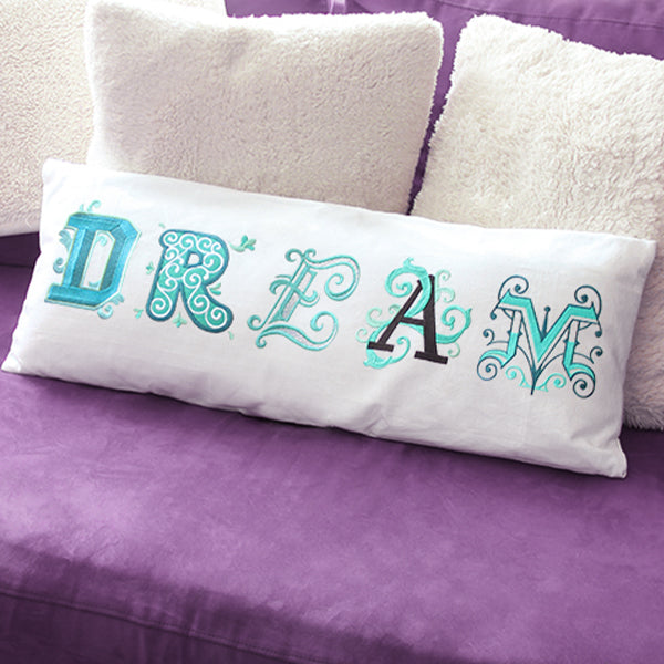 machine embroidery letters creating the word "dream" on a pillow