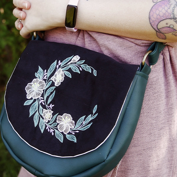 crossbody purse with machine embroidery design of a floral motif on it