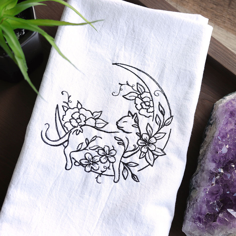 machine embroidery design of a cat on a floral moon stitched on a tea towel