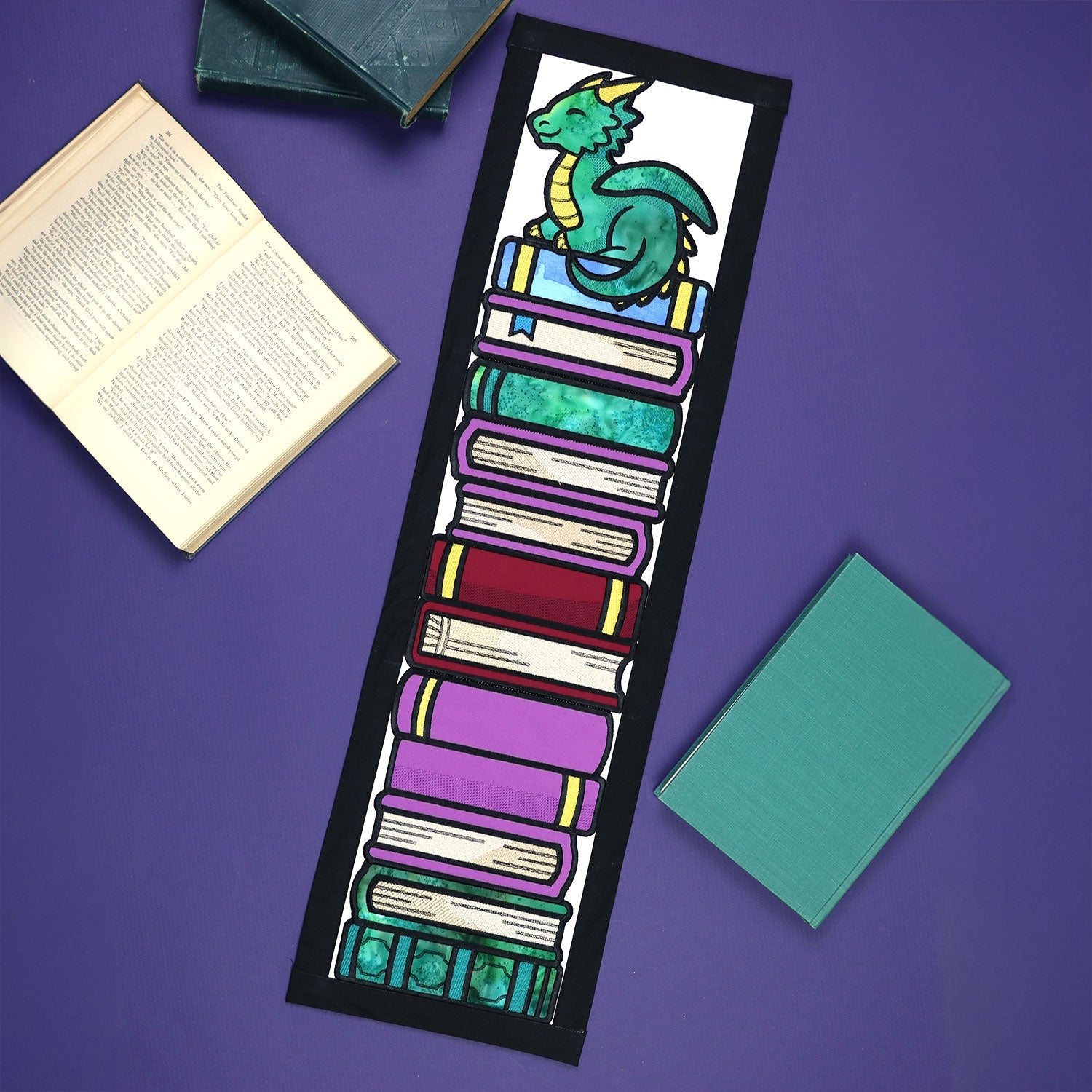 machine embroidered applique panel scene featuring a dragon and stack of books