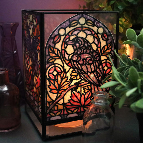 stained glass style machine embroidery design on a lantern featuring a crow and leaves motif