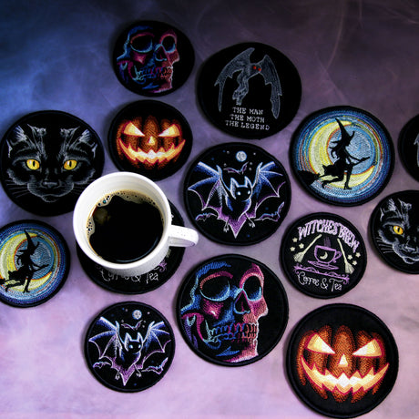 Collection of spooky, Halloween themed machine embroidery coasters on a purple background staged with a white coffee mug.
