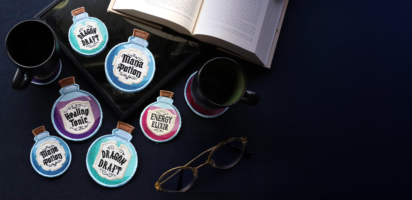 Set of potion-themed coasters on a dark surface with books and glasses.