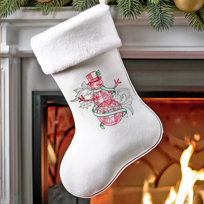 White Christmas stocking with a machine embroidered snowman design hanging by a fireplace.