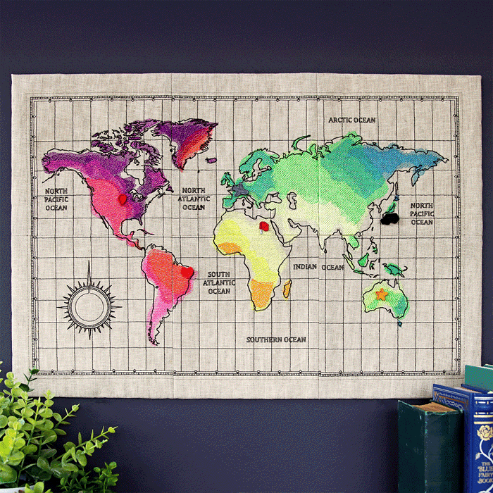 Gif of machine embroidered wall hanging world map, Paris on tote, and London on sweatshirt