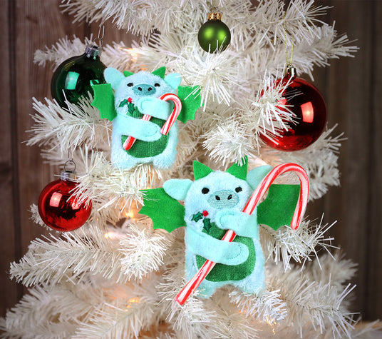 machine embroidery dragon candy hugger holding candy canes on a white Christmas tree