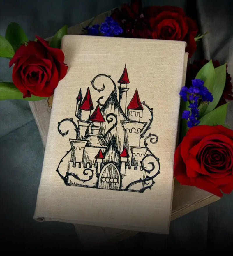 notebook with machine embroidery castle design surrounded by flowers.