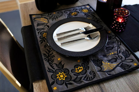 Decorative Halloween placemat with floral and spiderweb patterns on a table setting