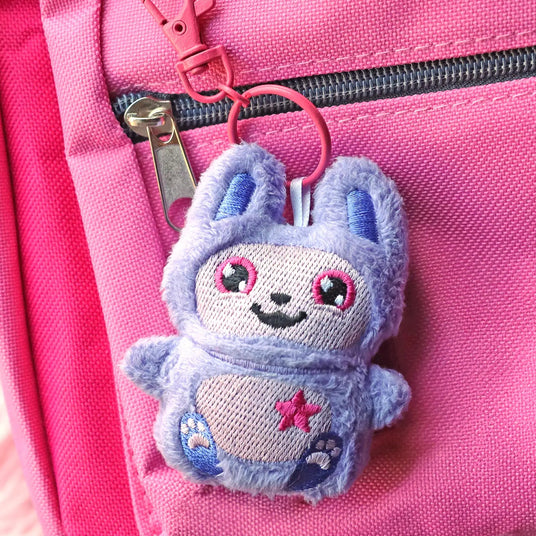 Machine embroidery in-the-hoop bunny keychain on a pink backpack