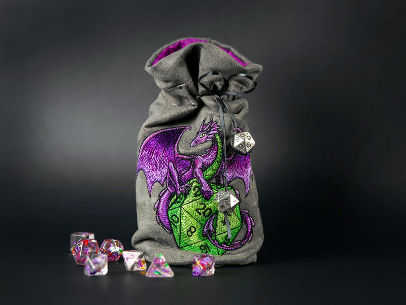 Drawstring bag with a machine embroidered dragon with d20 dice surrounded by dice.