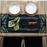 Green napkins on white plates, each embroidered with a digitally downloadable Celestial Flourish machine embroidery design.