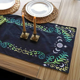 Embroidered celestial motifs in gold and white thread are stitched on dark fabric from a machine embroidery Design Pack.