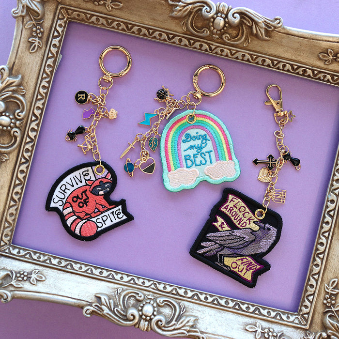 Machine embroidery keychain designs sitting in a gold frame with charms.