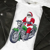 Embroidery of Santa Claus wearing sunglasses and riding a green motorcycle on a light gray fabric, partially covered by a black leather jacket.