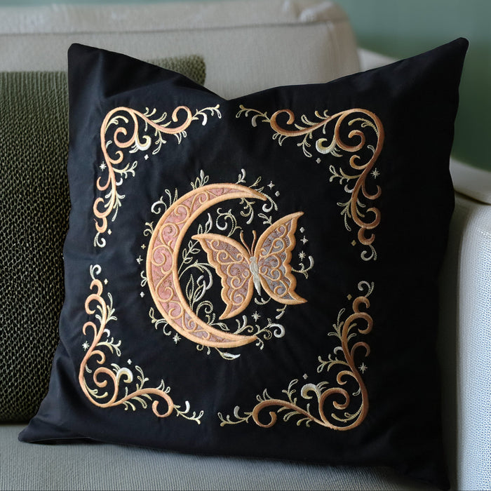 Decorative pillow with machine embroidered butterfly and crescent moon design on a couch.