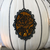 Digitally downloadable machine embroidery design of a white pumpkin with black glitter accents and a lace rose motif.
