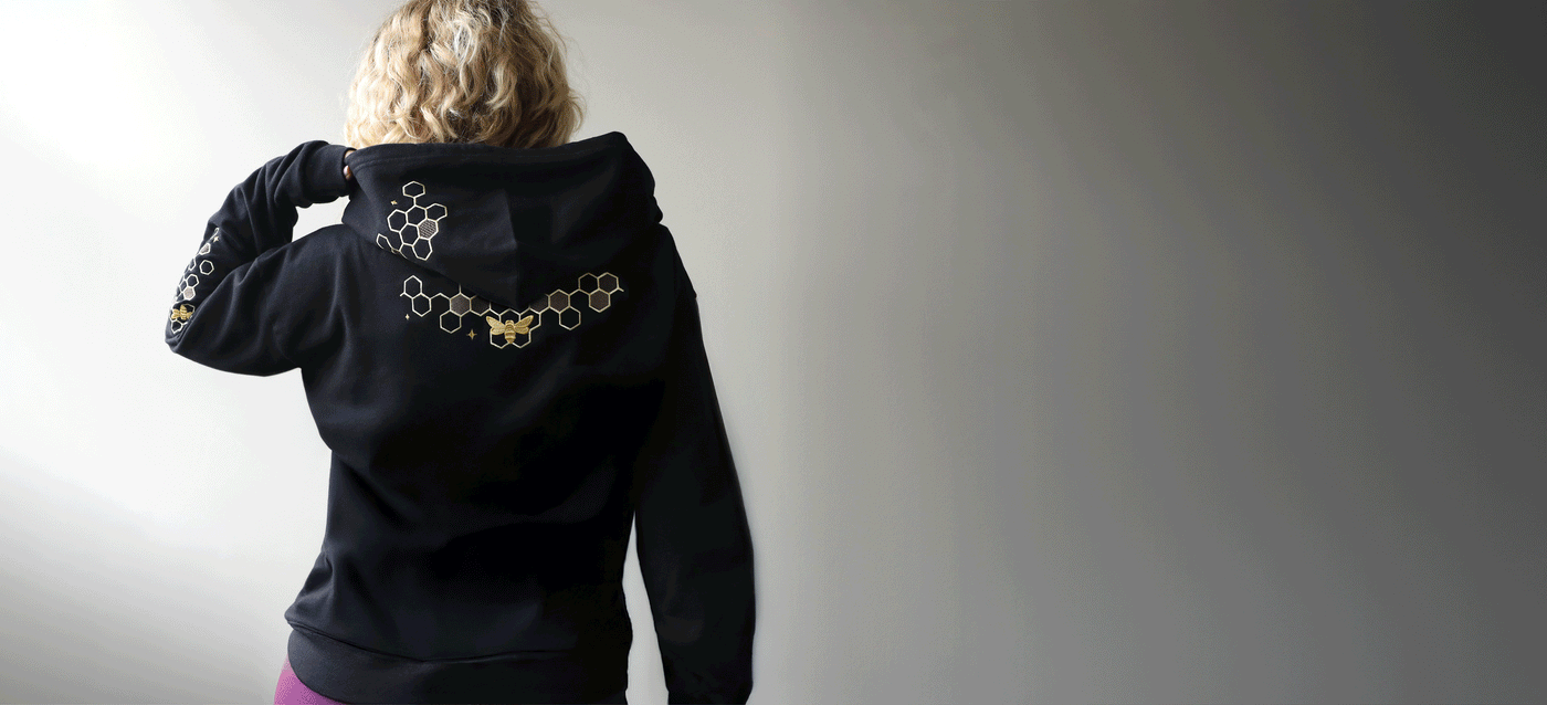 Gif of a person wearing machine embroidery bee and honeycomb designs on a black sweatshirt.