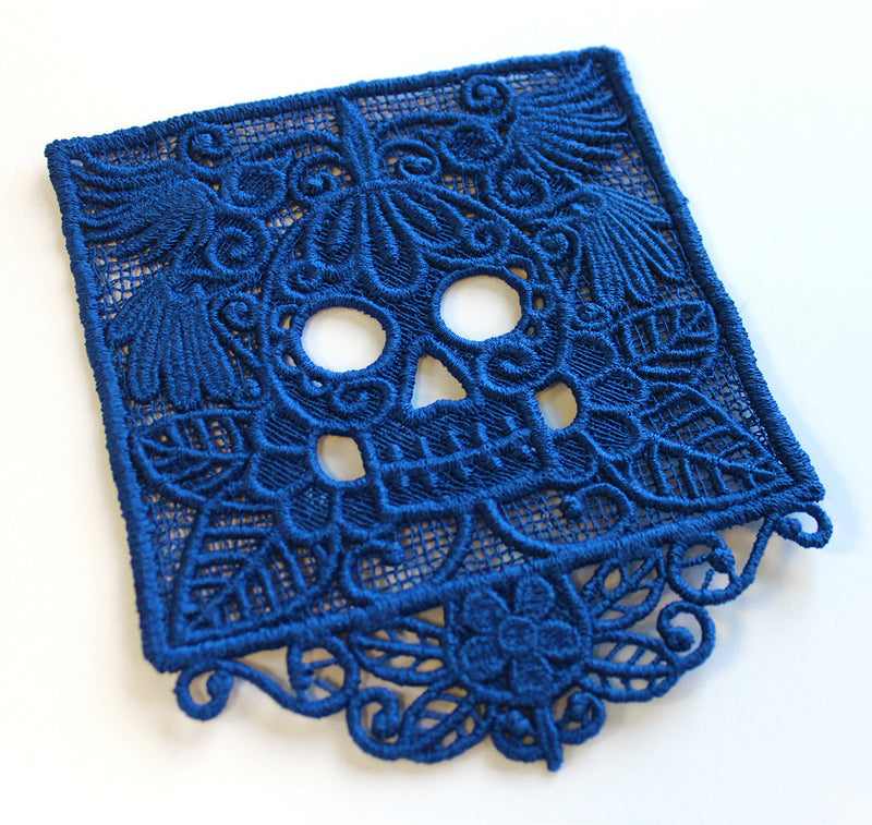 Machine embroidered blue lace doily on a white background