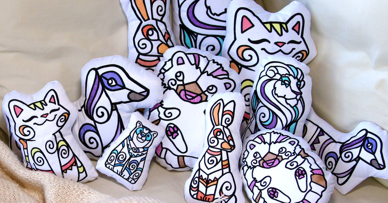 Colorful  machine embroidered plush animals created with bold swirl outlines with pops of thread colors.