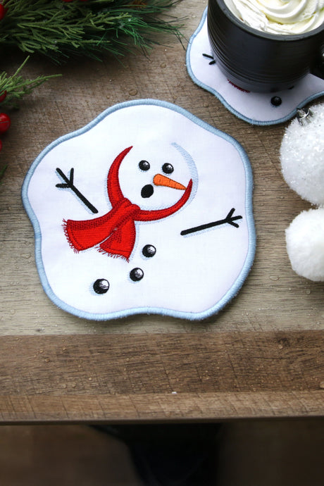 Machine embroidery snowman coaster on a wooden background