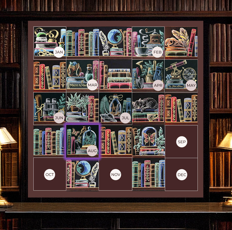 A framed monthly calendar art print featuring colorful machine embroidery designs of books, globes, quills, and decorative objects labeled with months, displayed against a dark wood library background.