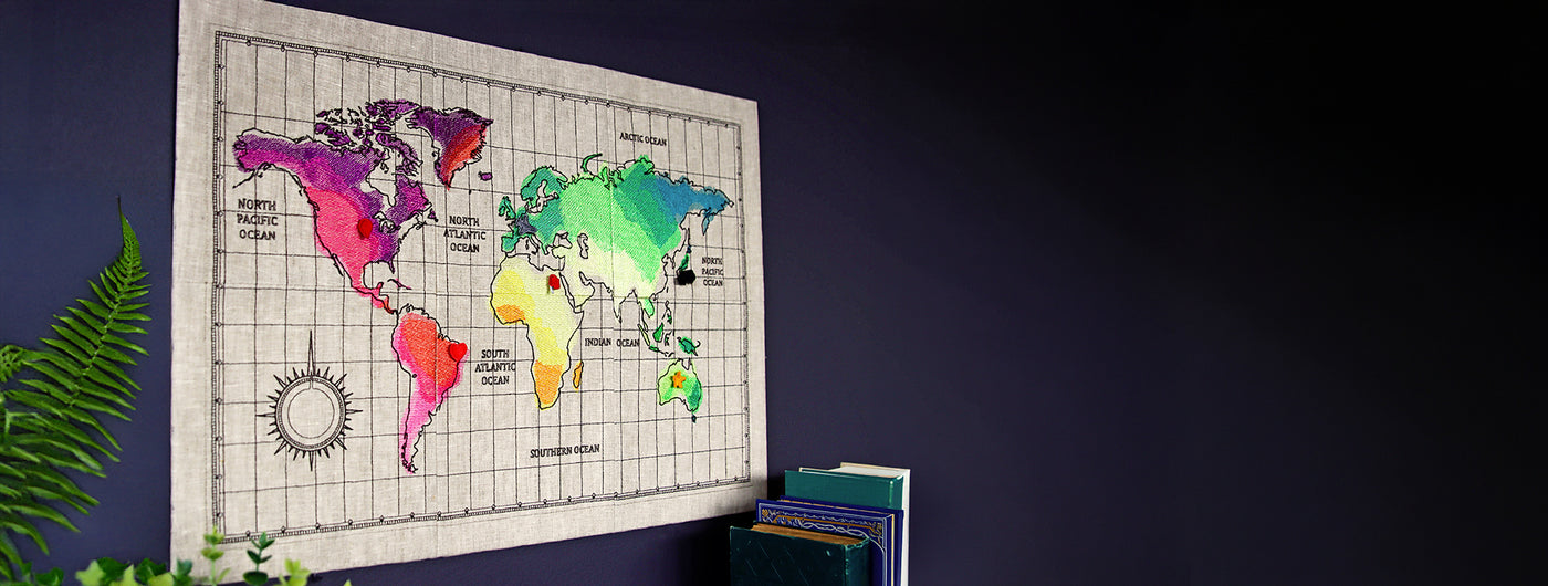 Machine embroidery world map design on a blue wall