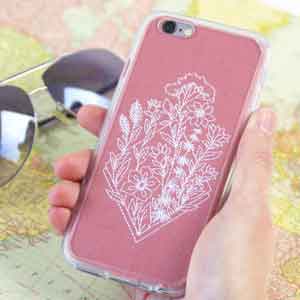 Machine embroidered floral design stitched on pink fabric and in a clear phone case.