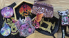 A collage of machine embroidered coasters, dragons, in-the-hoop stuffies, dice tray, zipper purse on a wooden table.